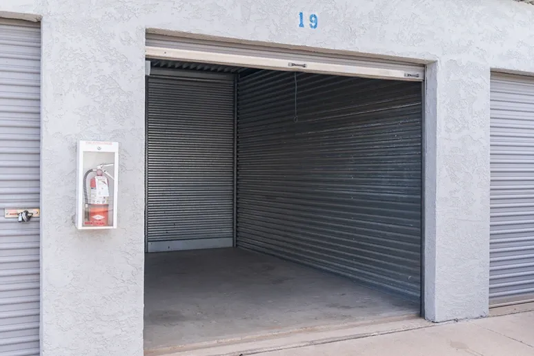 Empty drive-up storage unit with roll-up door open for easy loading access